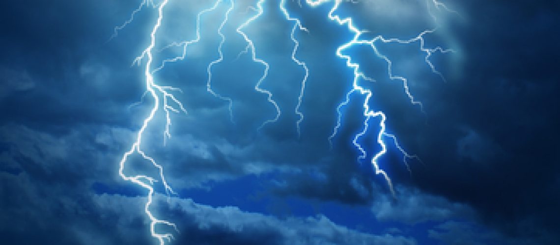 Powerful intelligence with an electric lightning bolt strike in the shape of a human head illuminated on a storm cloud night sky as a brain function neurology health care symbol.